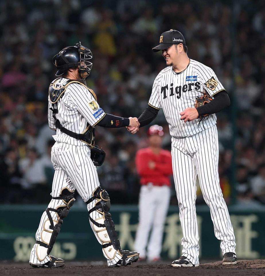 　登板を終え、梅野（左）と握手する岩貞（撮影・西田忠信）