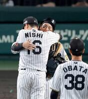 　２回、現役ラスト登板を終えた西勇（１６）と抱擁を交わす梅野（撮影・立川洋一郎）