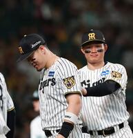 ８回の守備を終え、森下（右）に背中を押される佐藤輝（撮影・西田忠信）