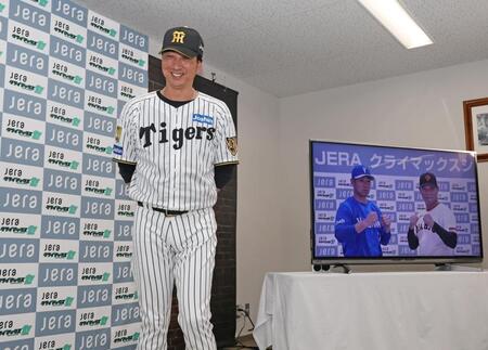 会見を終え微笑む藤川監督。モニター右から橋上監督代行、相川監督（撮影・中田匡峻）