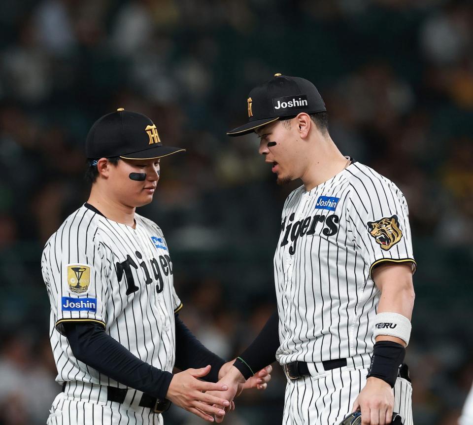 ５回の守備を終え、森下（左）に迎えられる佐藤輝（撮影・西田忠信）