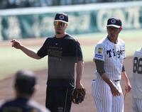 ノックを終え引き揚げる佐藤輝。右は田中内野守備走塁コーチ（撮影・中田匡峻）