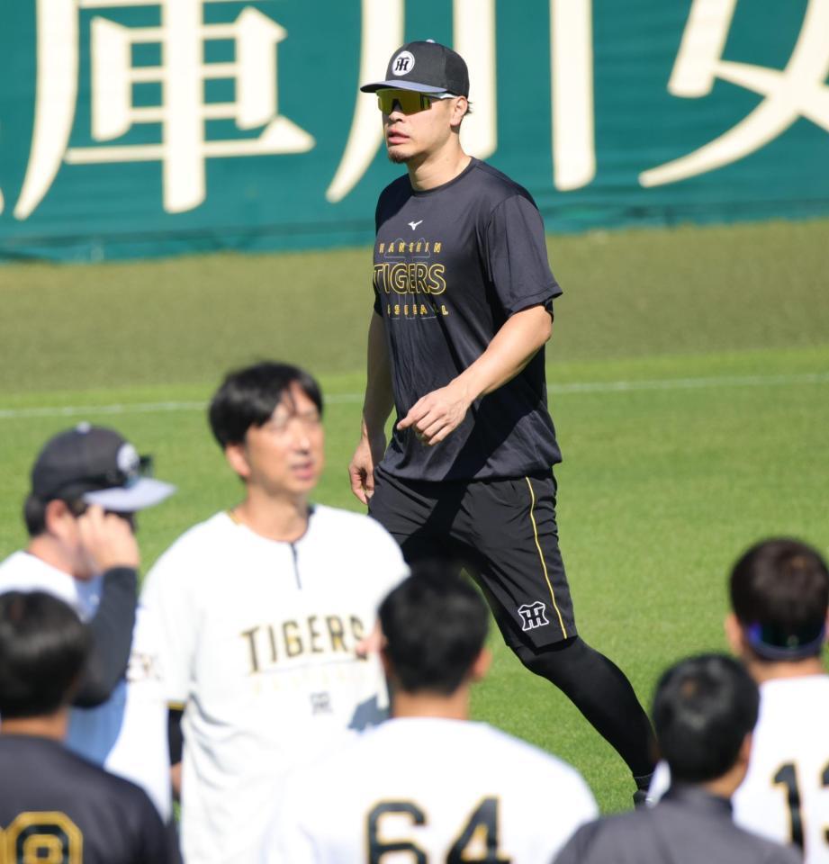 投手陣に訓示をする藤川監督の後方を通り過ぎる佐藤輝（撮影・坂部計介）