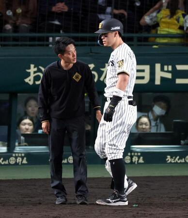 ８回、佐藤輝は自打球を受けトレーナーが駆け付ける（撮影・山口登）