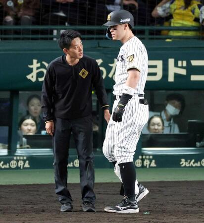 　自打球を受けた佐藤輝にトレーナーが駆け付ける（撮影・山口登）