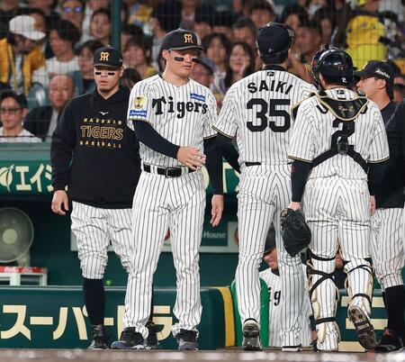 １回の守備を終えたナインを迎える佐藤輝（左）と森下（撮影・西田忠信）