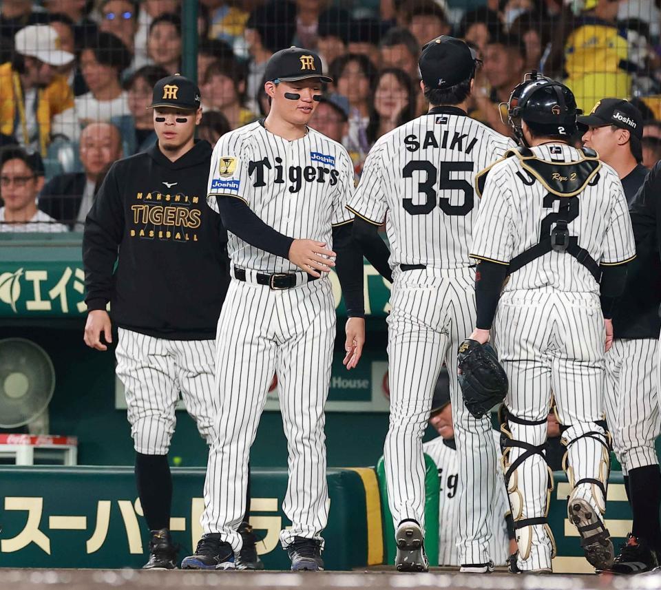 １回の守備を終えたナインを迎える佐藤輝（左）と森下（撮影・西田忠信）