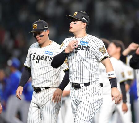 　ファンへのあいさつを終え、引き揚げる佐藤輝。左は森下（撮影・坂部計介）　