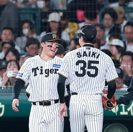 ２回を投げ終えた才木（右）を笑顔で迎える森下（撮影・西田忠信）