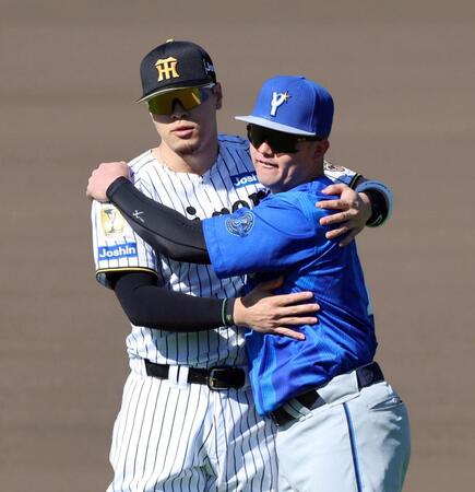 試合前、佐藤輝（左）は牧とハグする（撮影・山口登）