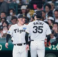 ２回を投げ終えた才木（右）を笑顔で迎える森下（撮影・西田忠信）