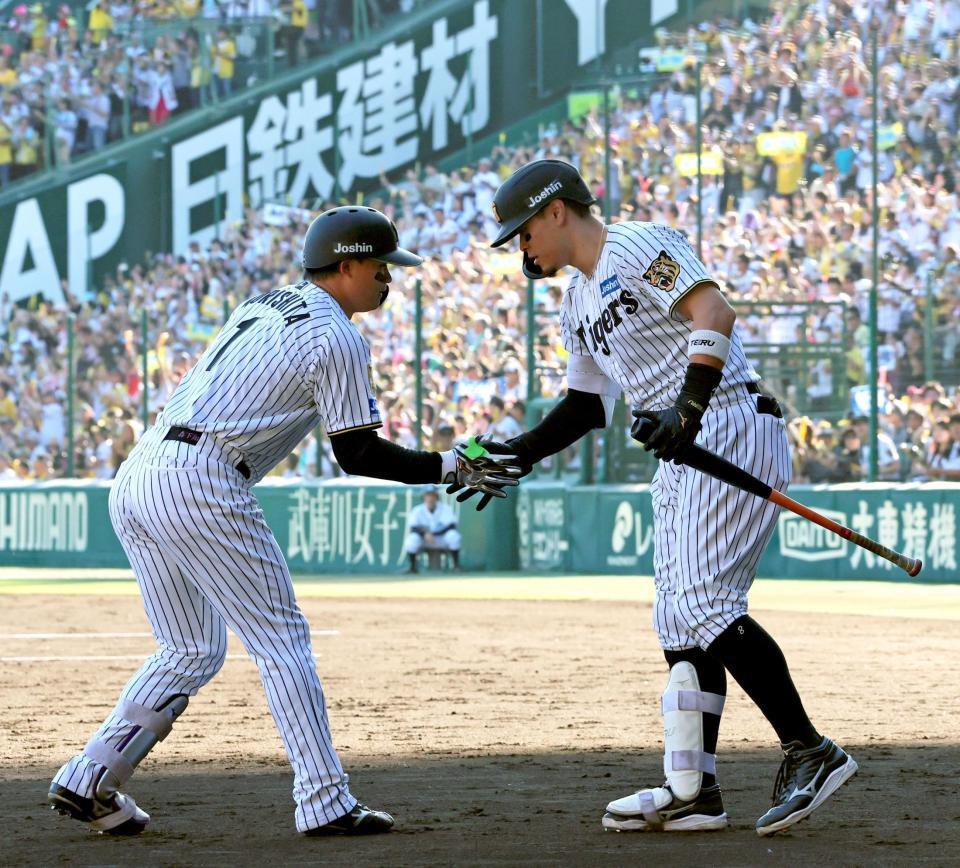 ５回、ソロを放って生還し、迎える佐藤輝（右）とタッチを交わする森下（撮影・立川洋一郎）