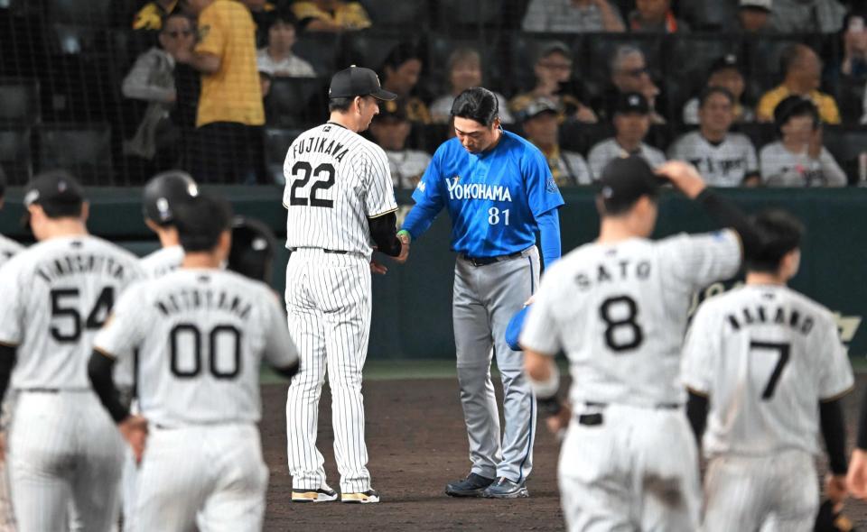 　健闘をたたえ合い握手を交わす藤川監督と相川監督（撮影・飯室逸平）