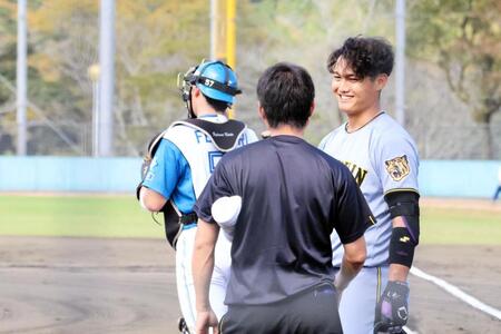 ２回、ヘルメットのつばに投球を受けた西純（右）はトレーナーに笑顔で無事を伝える