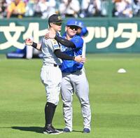 １７日の試合前、互いの健闘を誓い合う佐藤輝（左）と牧