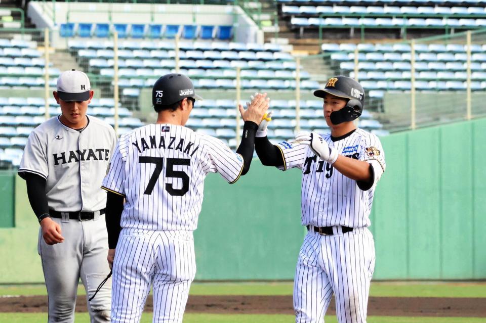 ７回２、左前適時打を放った立石（右）は、一塁上で山崎２軍内野守備走塁コーチ（７５）とハイタッチする