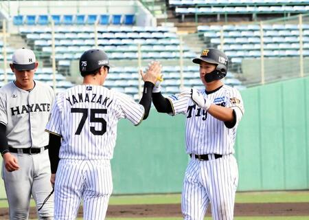 　７回、適時打を放った立石（右）は塁上で山崎２軍内野守備走塁コーチ（７５）とハイタッチする