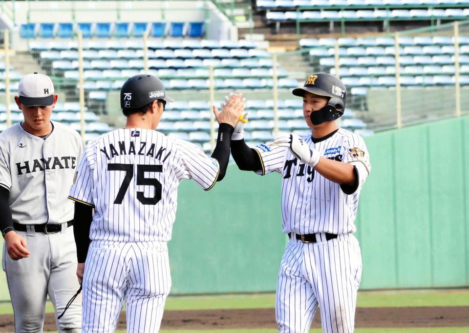 　７回、適時打を放った立石（右）は塁上で山崎２軍内野守備走塁コーチ（７５）とハイタッチする