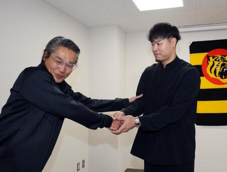 嶌村球団本部長（左）から激励を受ける佐藤輝（撮影・山口登）