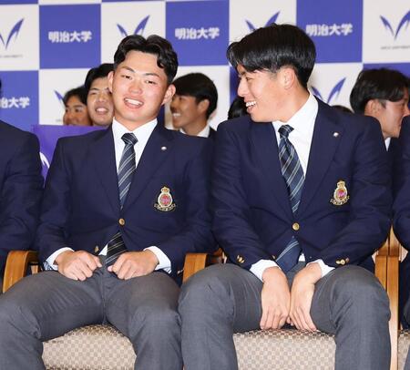 阪神から１位指名を受け、安どの表情を見せる明大・榊原七斗（左）＝撮影・中島達哉