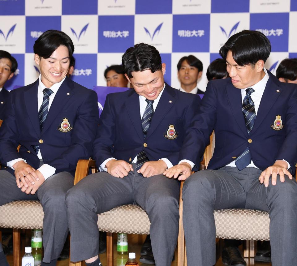 阪神から１位指名を受け、明大・松本直（右）と岡田啓吾（左）から祝福され、安どの表情を見せる榊原七斗（撮影・中島達哉）