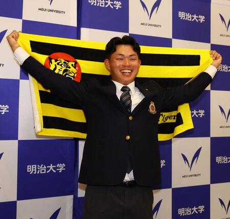 阪神からドラフト１位指名を受け、笑顔で記念撮影に応じる明大・榊原七斗（撮影・中島達哉）