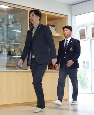 藤川球児監督（左）と会見場に入る阪神１位の明大・榊原七斗（撮影・西岡正）