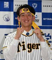 笑顔でファイティングポーズを決める阪神２位指名の日体大・馬場拓海（撮影・持木克友）
