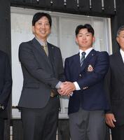 藤川監督（左）と握手を交わす阪神１位の明大・榊原七斗（撮影・西岡正）