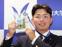 藤川球児監督のサインが入ったドラフトのパスを手に笑顔を浮かべる阪神１位の明大・榊原七斗（撮影・西岡正）