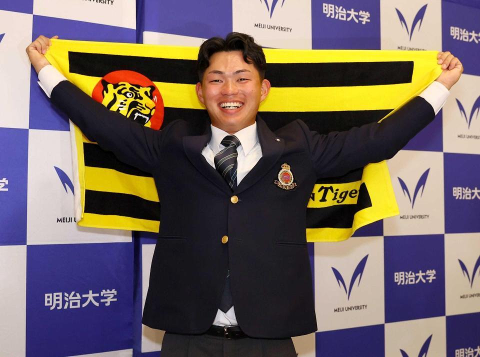　阪神からドラフト１位指名を受け、笑顔で記念撮影に応じる明大・榊原（撮影・中島達哉）