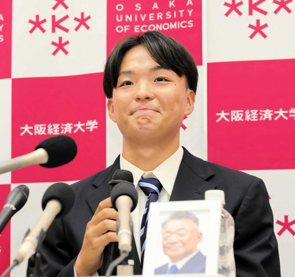 　高代延博さんの遺影とともに今後の決意を語る大経大・常深（撮影・大山伸一郎）
