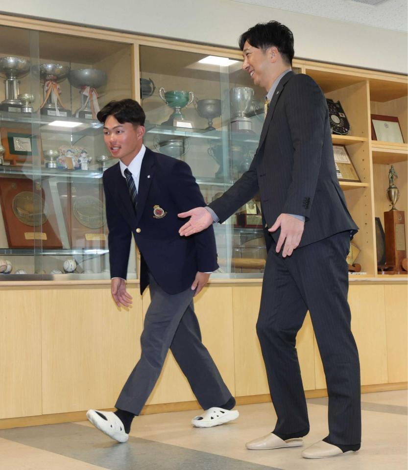 　藤川監督（右）にエスコートされ会見場に入る榊原