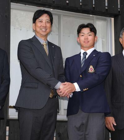 　ドラフト指名あいさつに訪れた藤川監督（左）と握手を交わす明大・榊原＝２３日