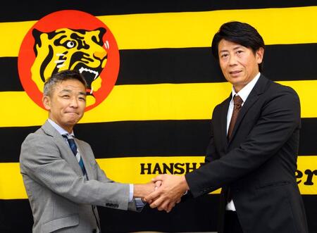阪神・竹内孝行球団副本部長（左）と握手を交わす的場寛一氏（撮影・山口登）