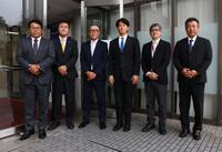 指名あいさつで記念撮影に応じる東編成ディレクター、平塚スカウト、畑山統括スカウト、日体大・馬場拓海、ドラフト２位指名の日体大・大石部長、日体大・古城監督（撮影・中島達哉）