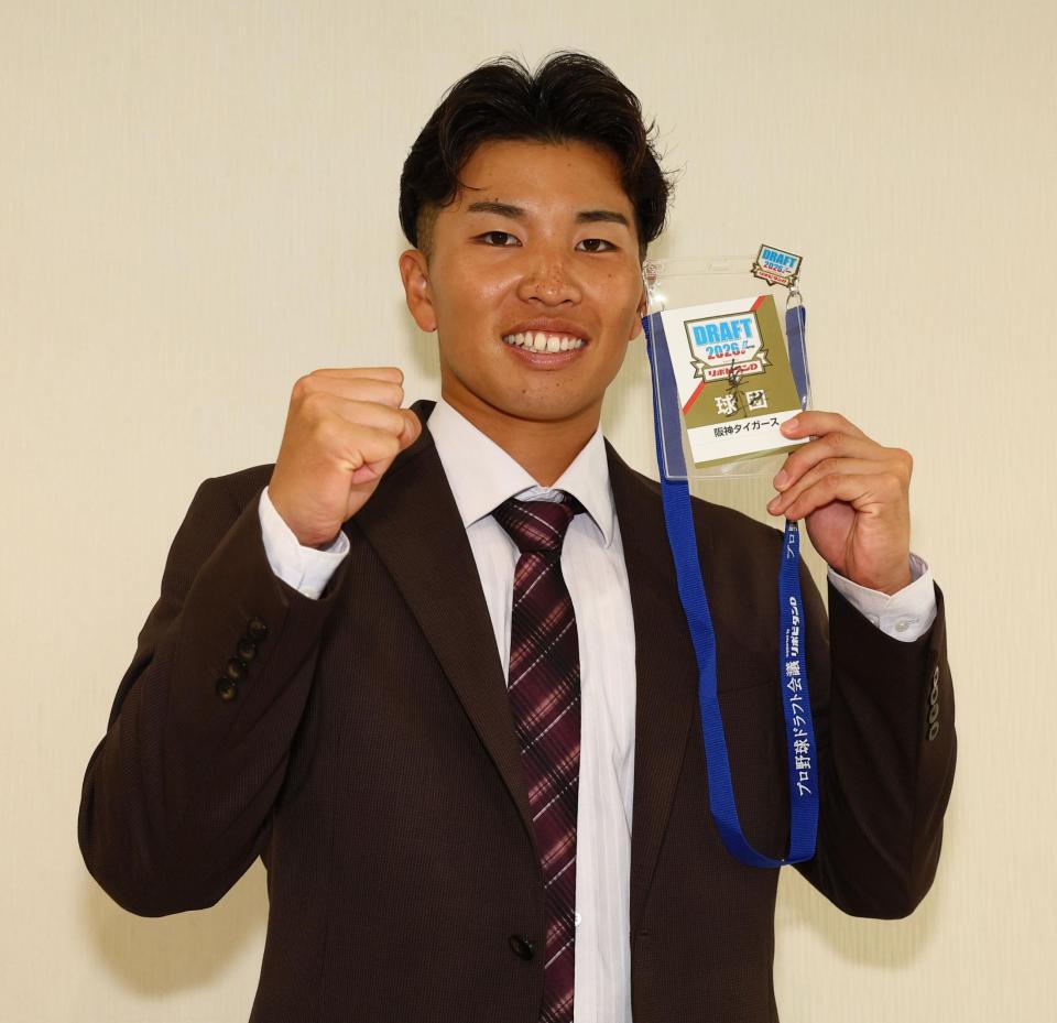ドラフトのパスを手に記念撮影に応じるドラフト６位指名の東京ガス・越川海翔（撮影・中島達哉）