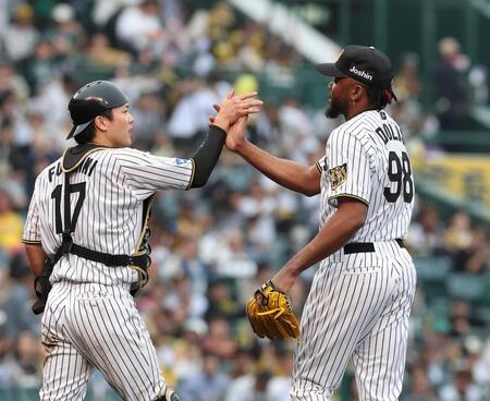 　巨人戦で最後を締めたドリス（右）とタッチを交わす伏見＝５月２日
