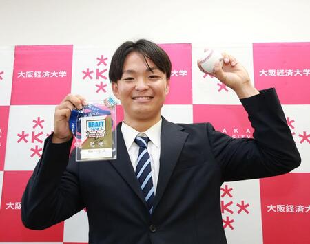藤川監督のサイン入りパスを手に笑顔を見せる大経大・常深颯大（撮影・西田忠信）