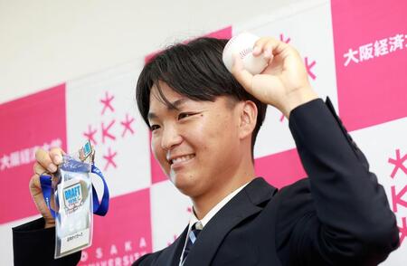藤川監督のサイン入りパスを手に笑顔を見せる大経大・常深颯大（撮影・西田忠信）