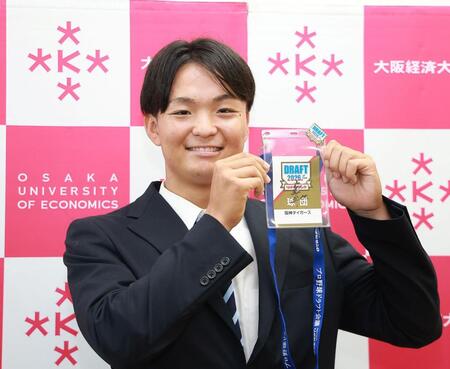藤川監督のサイン入りパスを手に笑顔の大経大・常深颯大（撮影・西田忠信）