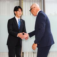 指名あいさつに訪れた畑山統括スカウト（右）と握手を交わす日体大・馬場拓海（撮影・中島達哉）