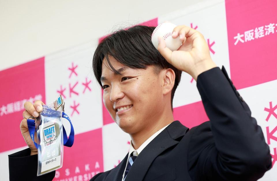 藤川監督のサイン入りパスを手に笑顔を見せる大経大・常深颯大（撮影・西田忠信）
