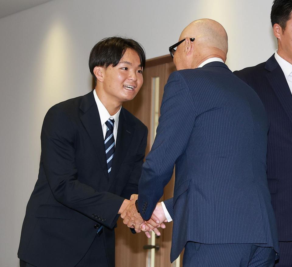 畑山統括スカウト（右）と握手をする大経大・常深颯大（撮影・西田忠信）