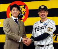 石川ミリオンスターズの新監督に就任した岩貞祐太氏。前監督の岡崎コーチ（左）と握手をかわす（撮影・山口登）