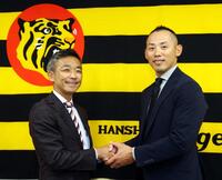 竹内孝行球団副本部長（左）と握手を交わす矢野謙次氏（撮影・山口登）