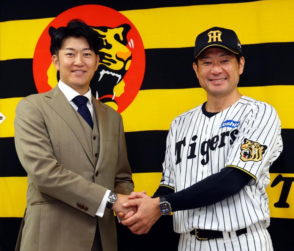 石川ミリオンスターズの新監督に就任した岩貞祐太氏。前監督の岡崎コーチ（左）と握手をかわす（撮影・山口登）