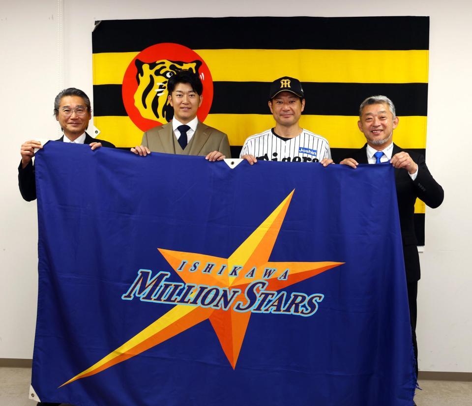石川ミリオンスターズの球団旗を手に、写真に納まる（左から）阪神・嶌村球団本部長、岩貞祐太氏、岡崎コーチ、端保聡社長（撮影・山口登）