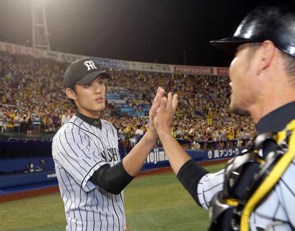 勝利を挙げた阪神・藤浪晋太郎は阪神・鶴岡一成とタッチを交わす＝横浜（撮影・田中太一）