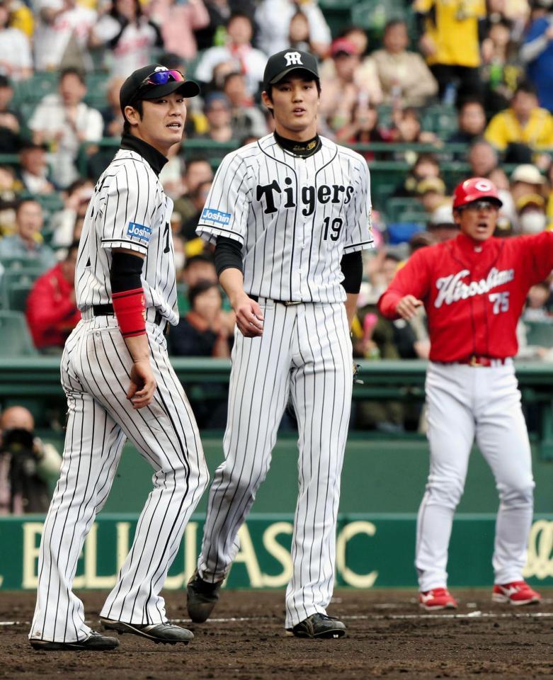 ６回広島１死二塁、田中広輔のバントの打球をを一塁に悪送球した西岡剛と勝ち越された藤浪晋太郎＝甲子園（撮影・持木克友）